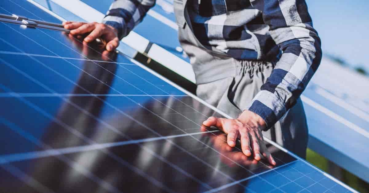 Imagen de un operario tocando un panel solar